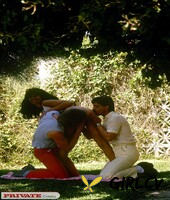 brunette female gets banged by two guys at once among ruins of stone building