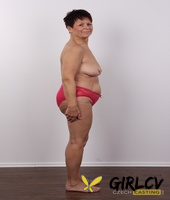 older amateur strips down to her birthday suit in front of a white wall