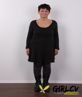 older amateur strips down to her birthday suit in front of a white wall