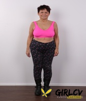 older amateur strips down to her birthday suit in front of a white wall