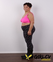 older amateur strips down to her birthday suit in front of a white wall