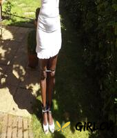 black girl is cleaved gagged and bound with her hands above her head in a yard